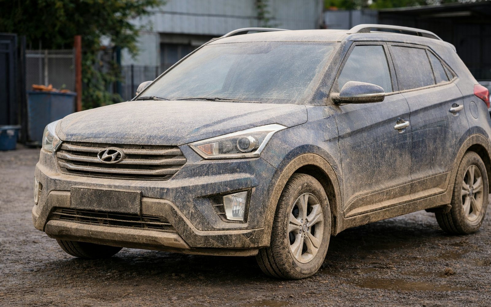 SUV azul coberto de barro e poeira, antes da lavagem